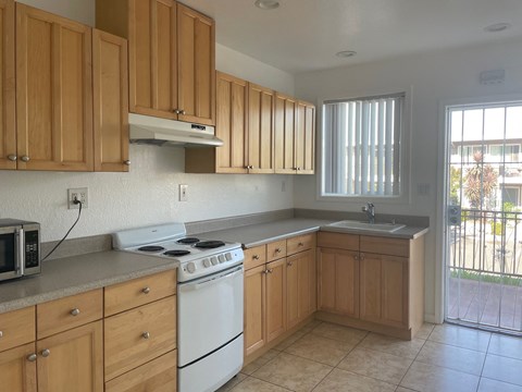 an empty kitchen with wooden cabinets and white appliances
